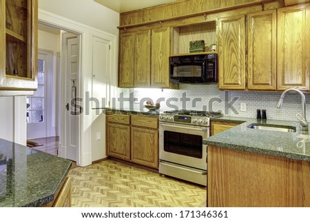 Classic small kitchen with wooden cabinets and modern appliances.  American home interior.