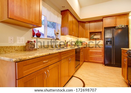 Bright Kitchen Room With Wooden Cabinets And Hardwood Floor