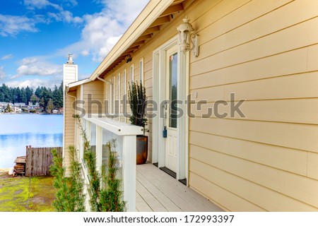 Wood deck with white railings overlooking beautiful lake