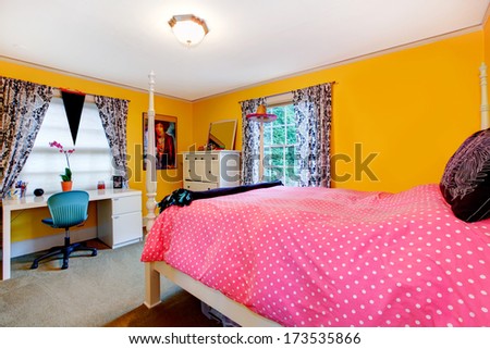 Comfortable yellow and pink young adult room with rustic white bed frame and wood cabinets