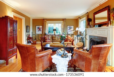 Cozy Family Room With Light Tone Walls, Old-Fashioned Furniture, Marble Table And Stoned Background Fireplace
