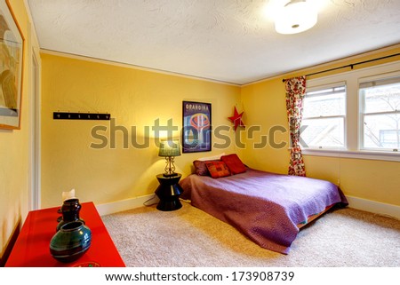 Yellow wall bedroom with bright red cabinet  and queen size bed