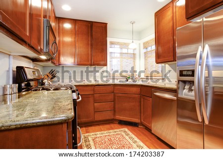 Small kitchen room with wood storage combination, modern appliances and light tone ceiling