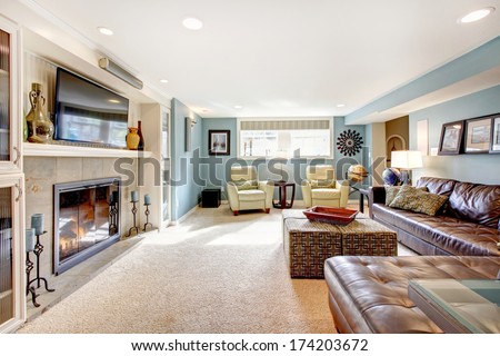 Light blue living room with leather furniture set, beige carpet floor, tv and fireplace