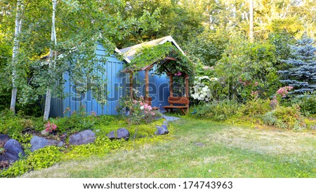 Farm house backyard with wood sheds, attached garden house,  flourishing flower bed