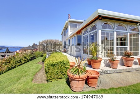 Amazing house with walkout deck, decorative big flower pots and trimmed hedges, Summer view