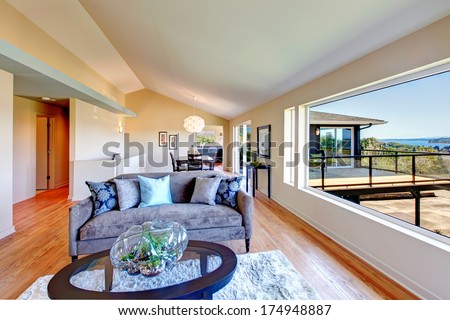 Bright Living Room And Dining Area With Vaulted Ceiling, Hardwood Floor And Walkout Deck