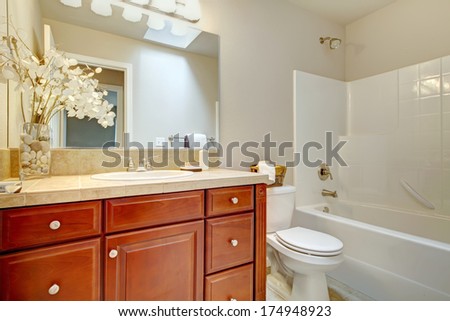 Light tones bathroom with wood cabinets. Decorated with beautiful dry flowers