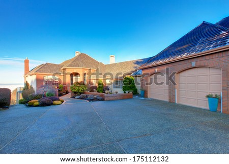 Large luxury brick house with tile roof and excellent curb appeal. Big garage attached with stoned drive way