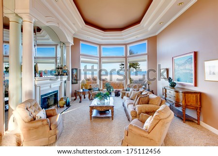 Rich Furnished Living Room With Coffered Ceiling And Colomns. Floor-To-Ceiling Angled Window Open A Charming View On Mountains