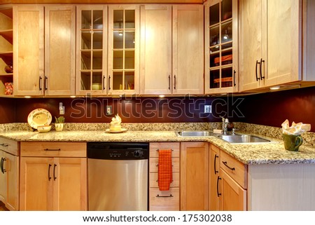 Light tones kitchen storage combination with burgundy backsplash and steel stove