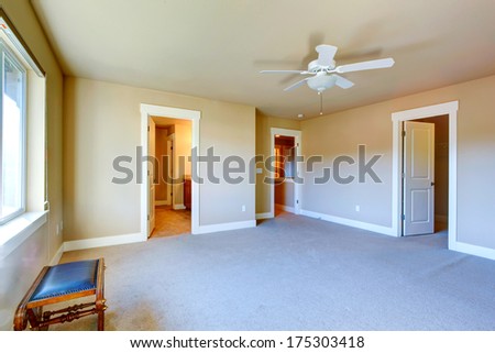 Bright empty room with carpet floor, ceiling fan has walk-in closet and bathroom