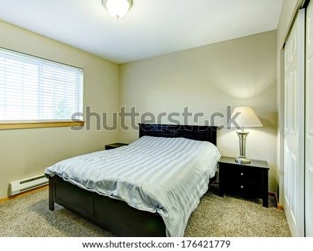 Small Cozy Bedroom With Closet, Beige Carpet Floor, Black Wood Bed And Nightstands