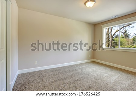 Bright Empty Room With One Window, Beige Carpet Floor And Ivory Walls