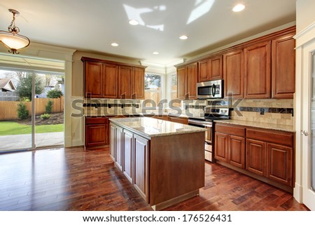 Beautiful Kitchen With Wood Storage Combination And Tile Decorated Back Splash. Kitchen Has A Walkout Deck