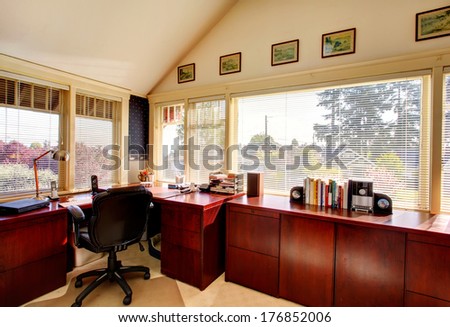 Vaulted ceiling office room with carpet floor, bright cherry cabinets, black whirpool chair