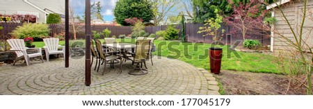 Cozy Backyard Area With Stoned Floor, Patio Table Set And White Chairs