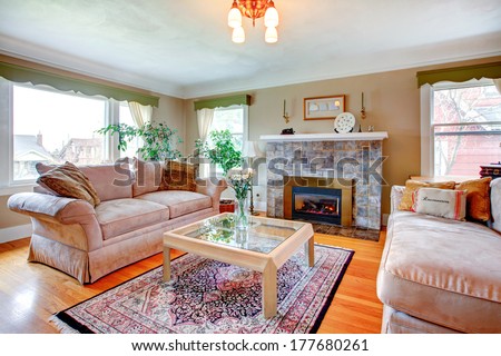 Bright Cozy Living Room With Hardwood Floor And Rug, Fireplace, Piano And Comfortable Sofas. Table Decorated With Fresh White Flowers