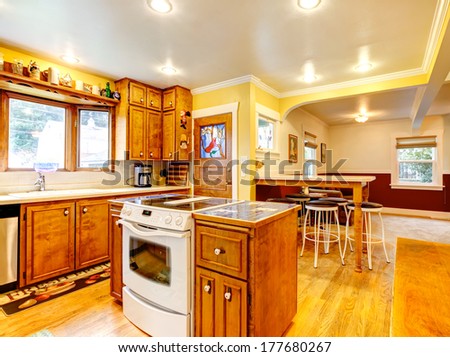 Bright Kitchen With Rustic Wooden Storage Combination, White Stove And Bar Counter With Stools