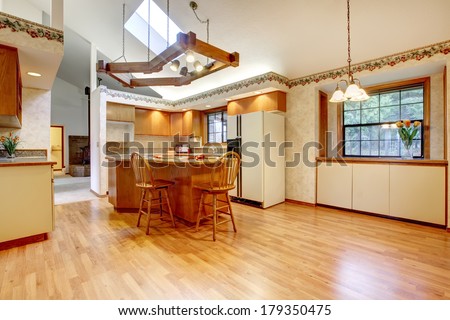 Bright farm house kitchen room with vaulted ceiling and hardwood floor. Design solution of lighting.