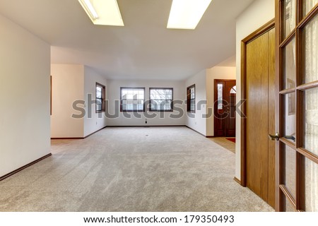 View of the empty room with beige carpet floor and windows