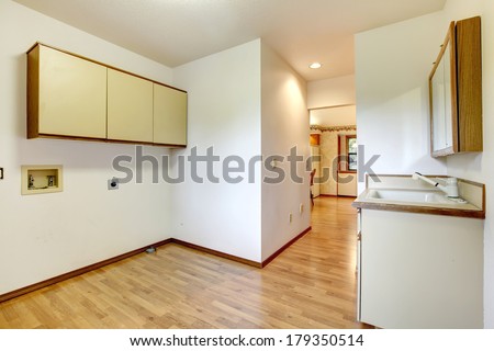 Empty room with a washbasin cabinet and wall cabinets.