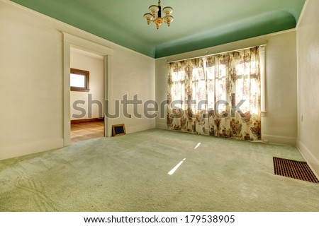 Empty bright room with one window, beige carpet floor.