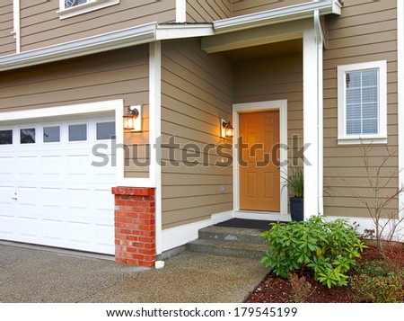 VIew ot the entrance orange door and garage form a walkway