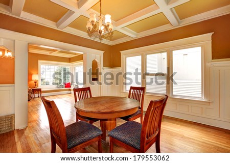 Bright dining room with a coffered yellow and white ceiling, hardwood floor. View of the living room