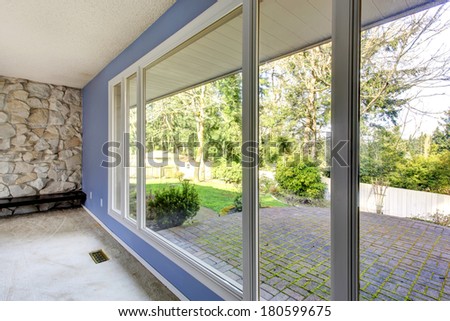 Lavender wall with big window. View of the backyard brick floor deck through the window
