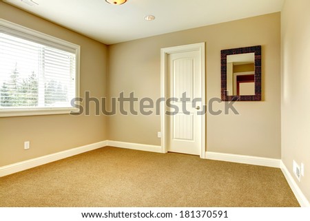 Empty room with window, carpet floor and mirror
