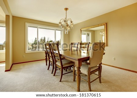 Warm colors dining room with carved wood table set and mirror
