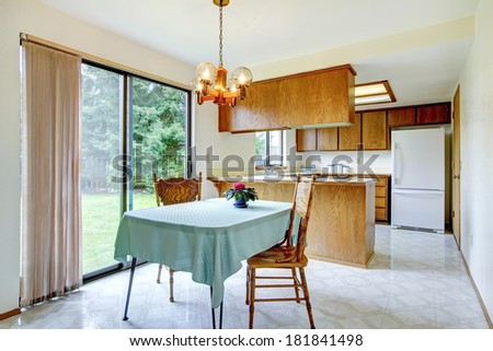Cozy kitchen with dining area. View of carved wood dining table set decorated with flower pot