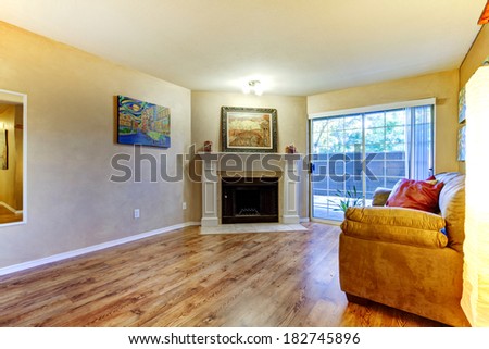 Living room with fireplace and couch. View of french slide doors. Room decorated with paintings