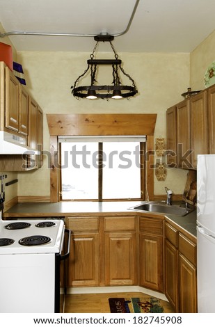 Small simple kitchen room with handicraft iron chandelier and white  old stove