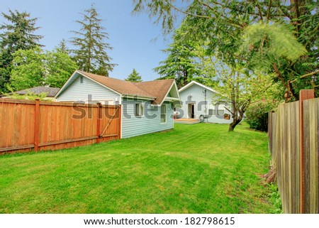 Fenced side yard with green lawn, View of the back yard deck