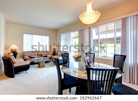 Bright living room with elegant leather furniture set, glass top coffee table and dining table set