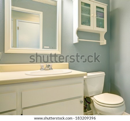 White old fashion bathroom vanity, glass door cabinet and toilet.