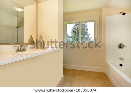 Bathroom interior in gentle light tones. View of built-in washbasin stand and bath tub