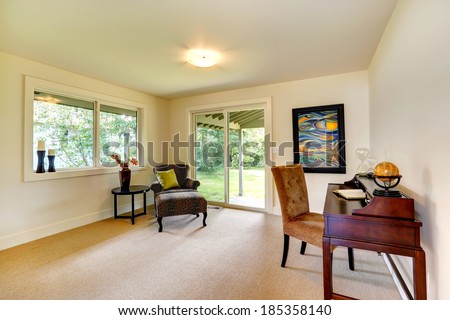 Bright room with windows, slide doors and carpet floor. Furnished with chairs, small coffee table and antique cabinet