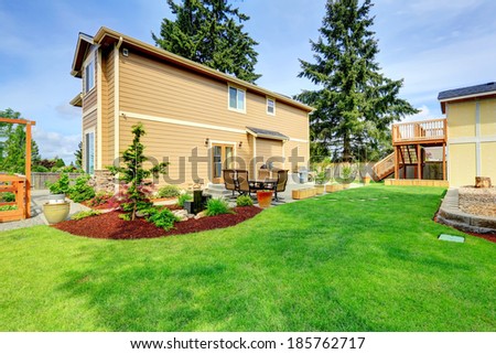 Big house with backyard patio area and beautifully designed flower bed