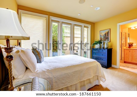 Beautiful bedroom with walkout deck and bathroom. View of refreshing white bedding and pillows