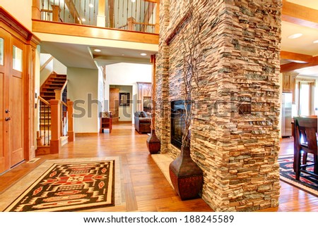 Beautiful stone wall with built-in fake fireplace. Two vases with dry branches complete the wall look