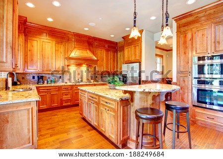 Beautiful kitchen with gold cabinets and steel appliances. Tile back splash trim complete with rich look.