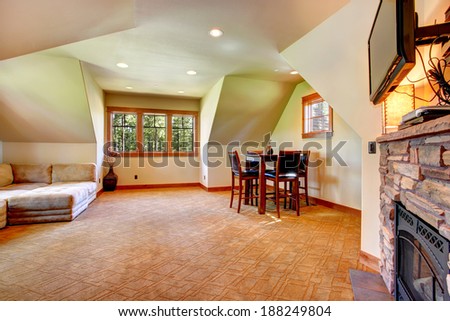 Spacious room with vaulted ceiling. View of stone background fireplace with tv, coach and table set next to the wall