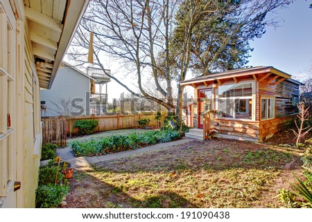 Fenced backyard with wooden shed.