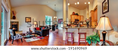Living room with dining area and kitchen. Panoramic view of open floor plan