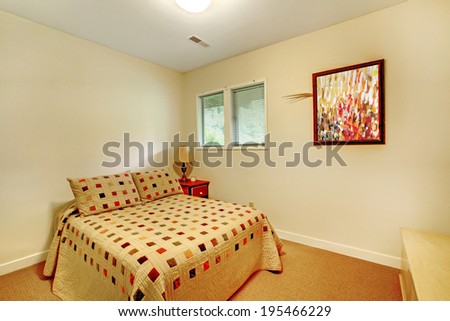 Light tones small bedroom with carpet floor and small bed covered in pleated colorful bedding