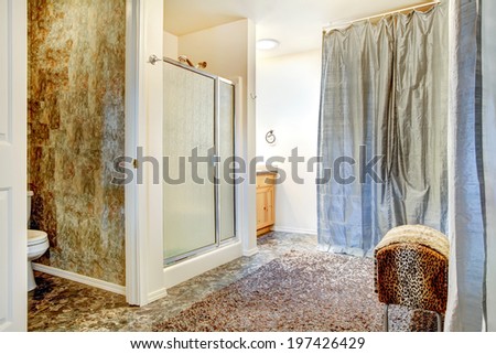 Spacious bathroom with tile floor and tile wall trim. View of shower door shower