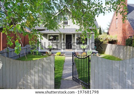Small old house. Front fenced yard with open gate. View of walkway and entrance porch